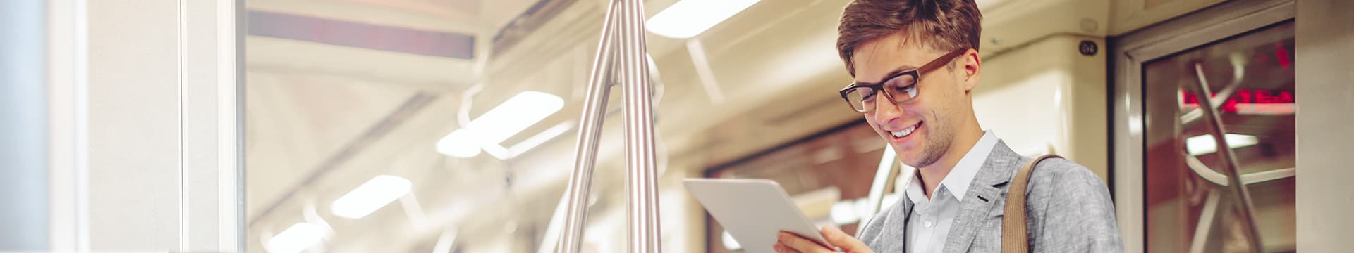 Young man checking tablet while on the subway