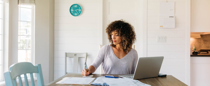 woman looking through documents and laptop
