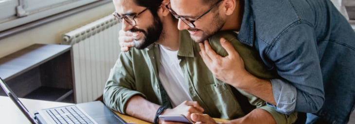 Young partners smiling at laptop