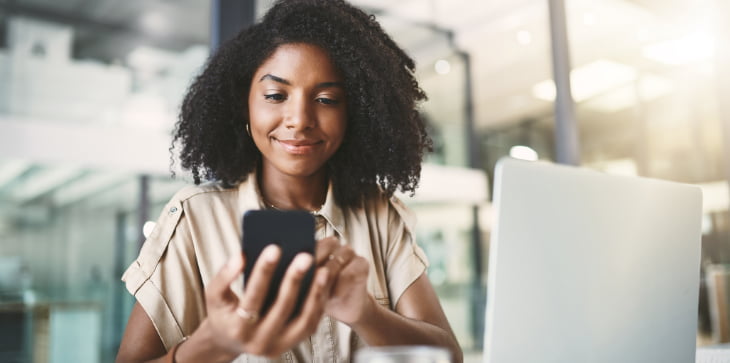 Young woman tapping phone smiling