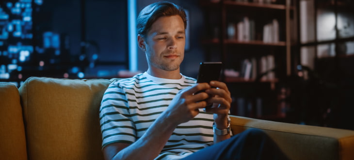 young man looking at cellphone at night