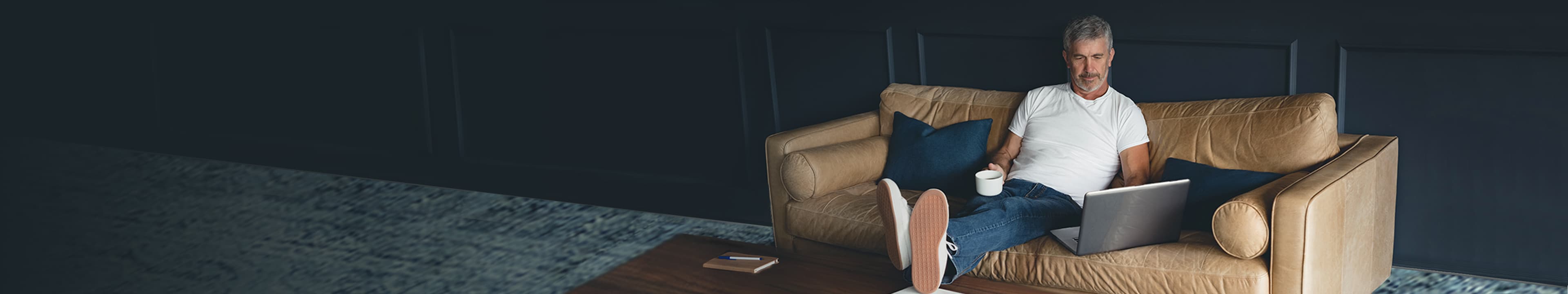 Homme âgé utilisant un ordinateur portable sur un canapé