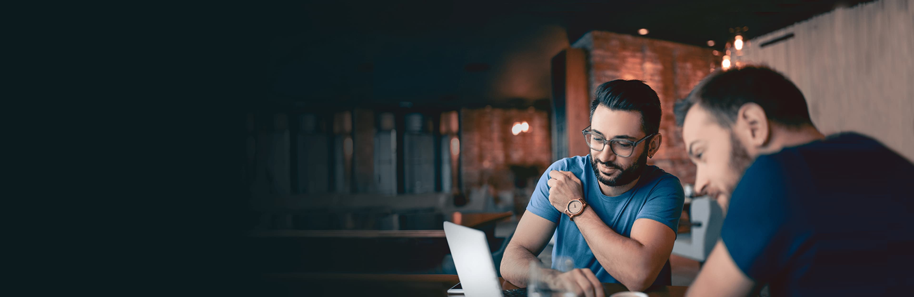 Hommes qui consultent le site Web de Questrade à partir de leur ordinateur portable